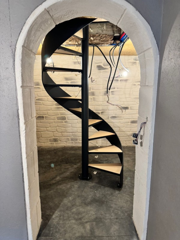 Création et installation d'un escalier hélicoïdal acier avec marche bois acacia pour accès à une cave à vin sur Dieppe 76